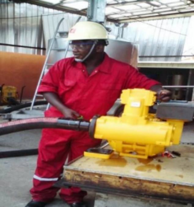 An engineer with red overall and white safety helmet operating a flow calibration machine